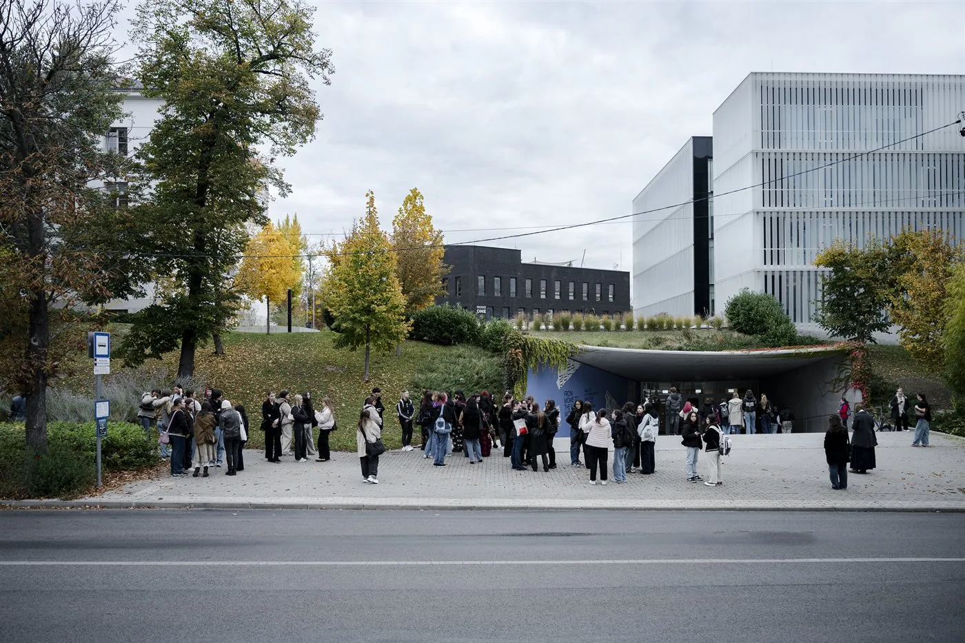 Students gathered outside a MOME university building on an autumn day