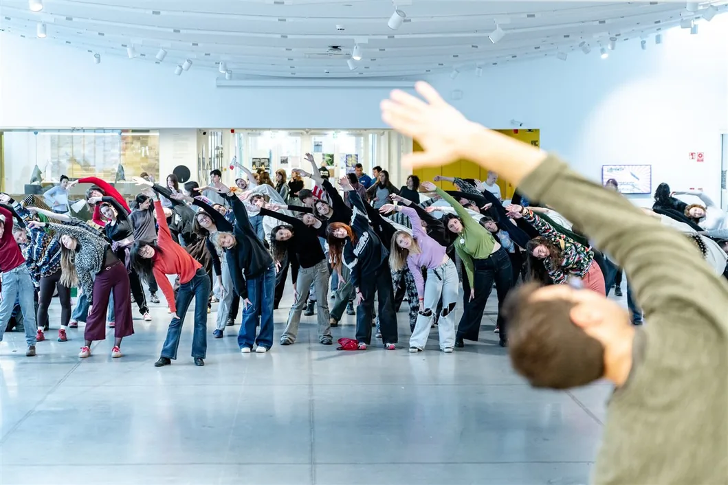 A large group of MOME students stretching together at a campus event